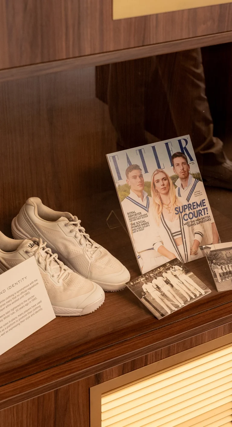 Wimbledon suite lifestyle scene with magazine and trainers — brand experience detail